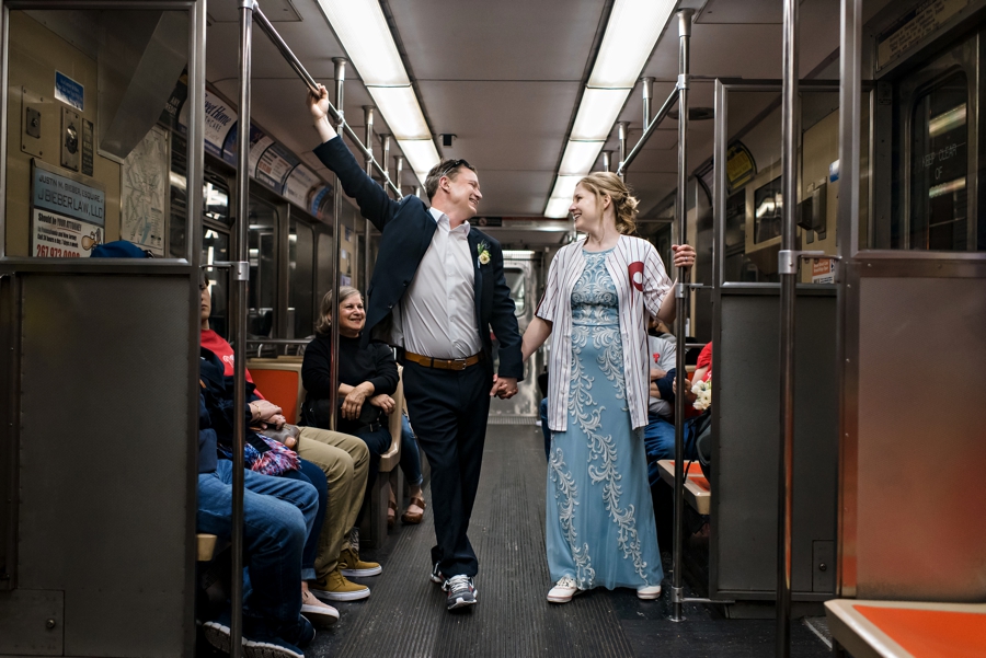 A wedding couple hold hands on the subway in Philly after their wedding.